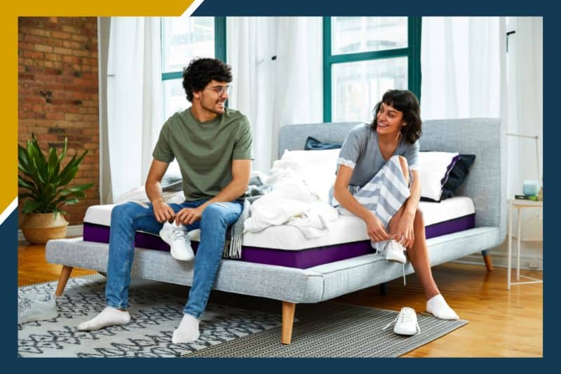 man and woman sitting on a Polysleep bed putting their shoes on and smiling